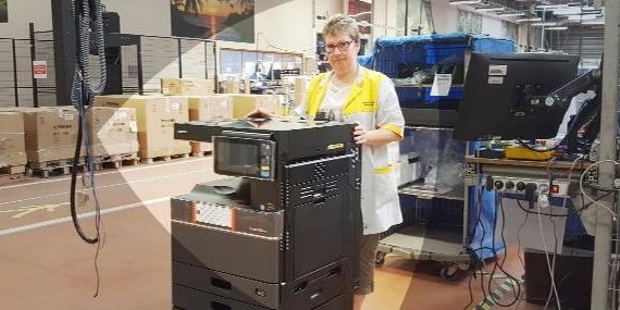 Femme remettant en état un photocopieur dans une usine de reconditonnement