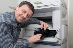 technicien réparant un photocopieur 